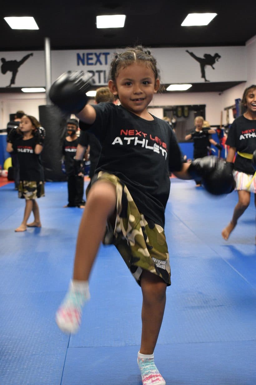 Young student practicing a Muay Thai kick at Next Level Martial Arts