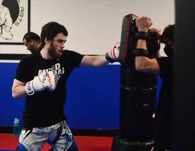 Adult student drilling punches on the pads at Next Level Martial Arts